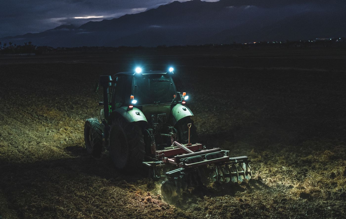 Trator trabalhando no campo à noite